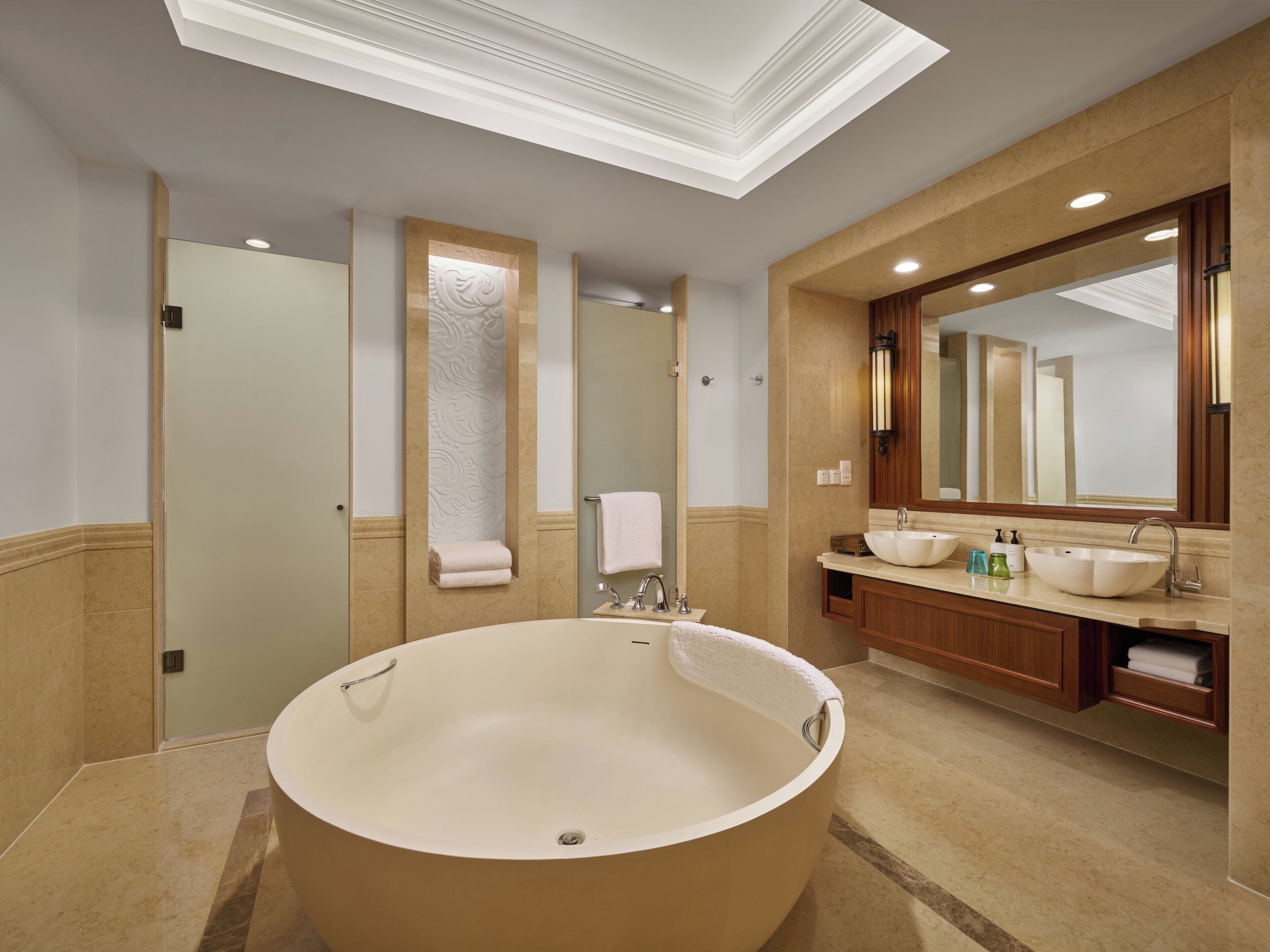 A modern bathroom with a freestanding bathtub, a large mirror, and a vanity with a sink.