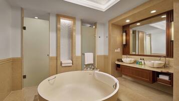 A modern bathroom with a freestanding bathtub, a large mirror, and a vanity with a sink.