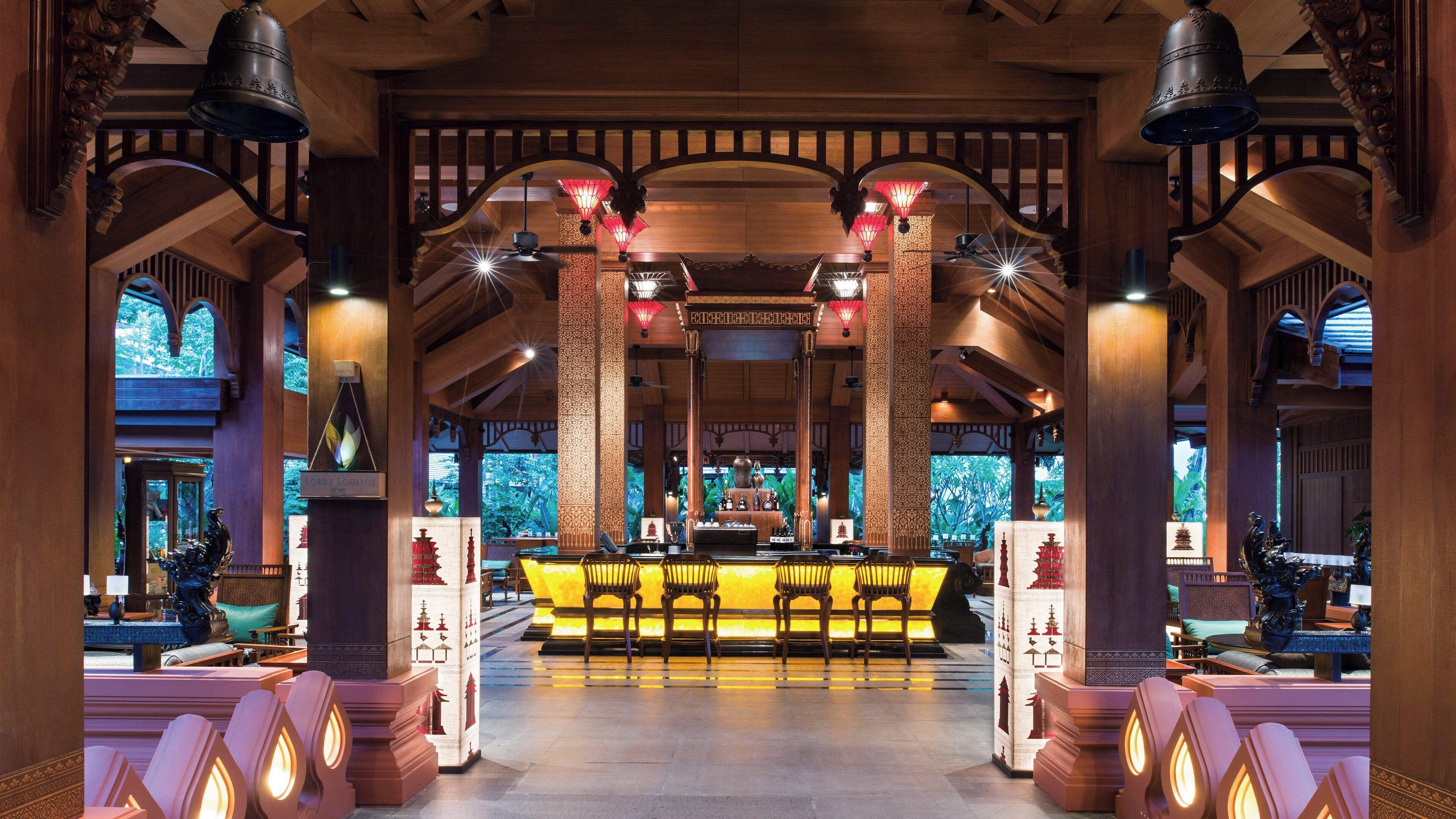 A lobby with a reception desk, seating area, and decorative elements like lanterns and columns.