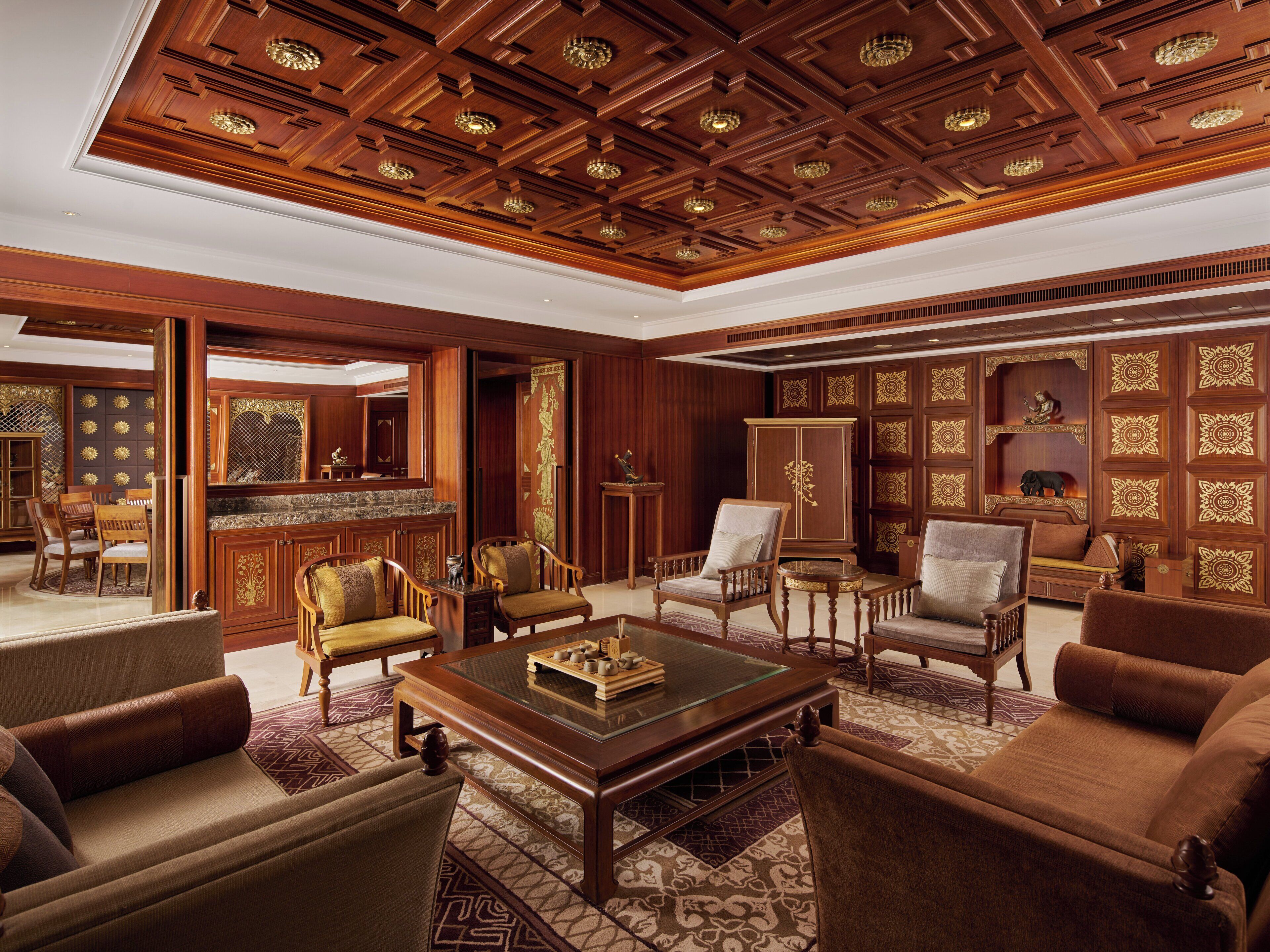 A spacious living room with a high ceiling, wooden paneling, and a large cabinet.