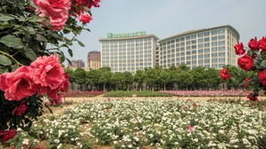 A hotel with a large building and a garden with roses. - Holiday Inn Nanyang by IHG (Nanyang)