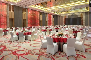 A banquet hall with round tables, white chairs, and red tablecloths. - Holiday Inn Nanyang by IHG (Nanyang)