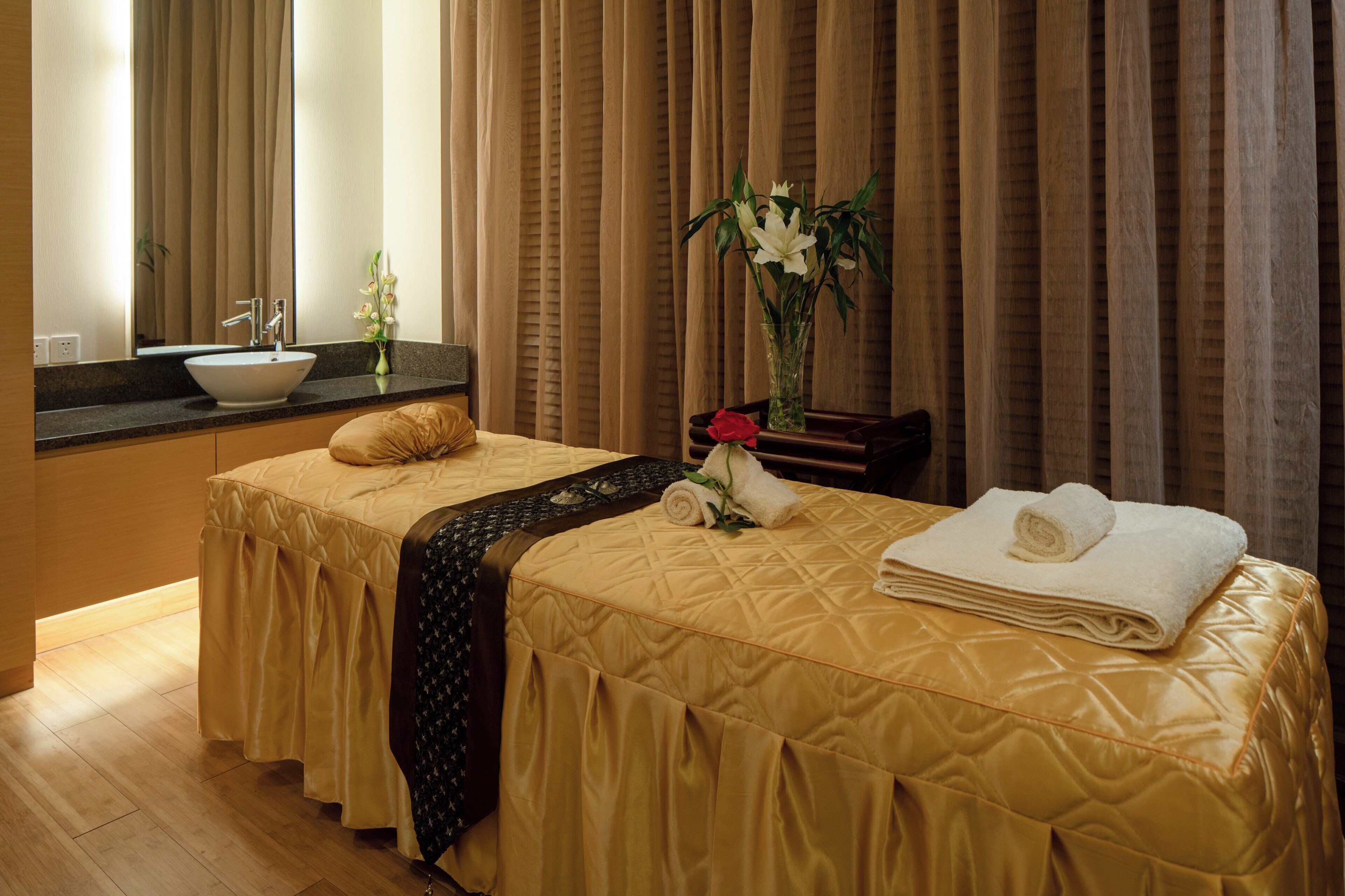 Habitación de hotel con dos camas, baño y un amplio ventanal con cortinas.