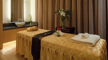 Habitación de hotel con dos camas, baño y un amplio ventanal con cortinas.