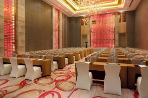 A conference room with rows of tables and chairs, equipped with water bottles and nameplates.