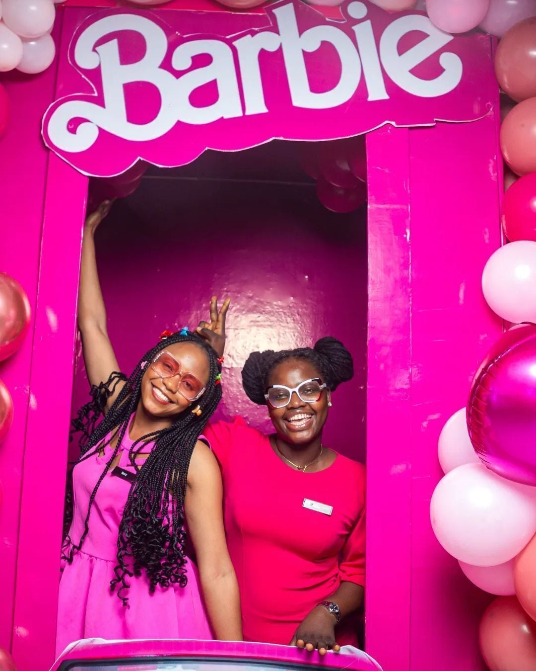 Un photomaton décoré aux couleurs roses et sur le thème de Barbie, avec des ballons.