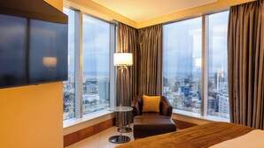 A hotel room with a large window, a flat-screen TV, a sofa, and a standing lamp. - Lagos Continental Hotel (Lagos)