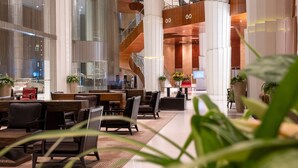 A spacious lobby with high ceilings, a central staircase, and multiple seating areas. - Lagos Continental Hotel (Lagos)