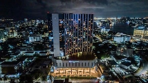 Et højt hotel med moderne design, karakteriseret ved en markant, vertikal facade og et godt oplyst indgangsparti.
