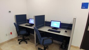 Un espacio de trabajo con dos escritorios, cada uno con computadora, teclado y silla.