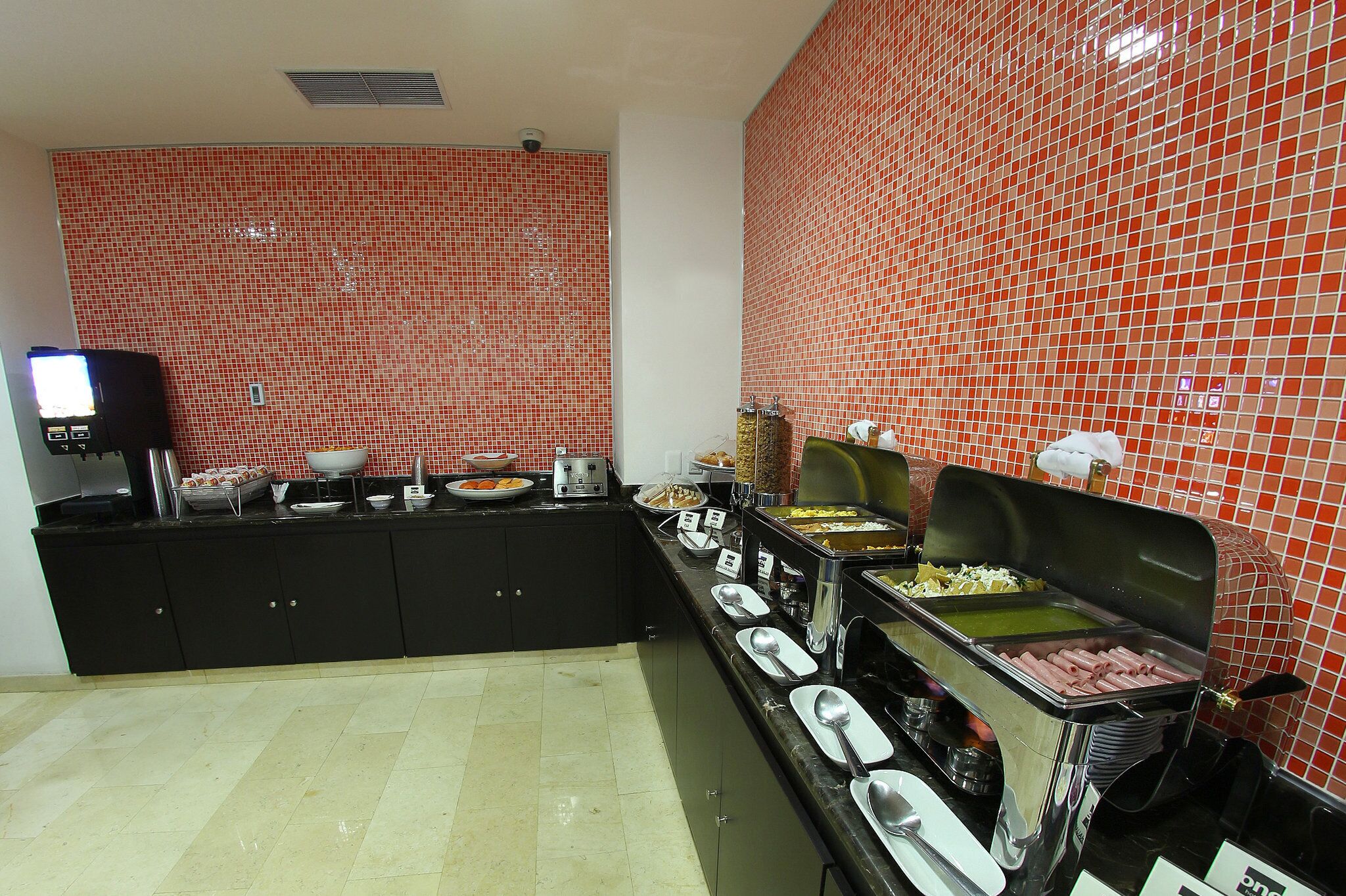 A buffet setup with various food stations and a coffee machine.