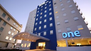 Un hôtel reconnaissable à son grand panneau indiquant le chiffre « 1 », à ses nombreux étages et à son entrée abritée.