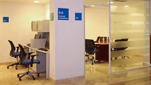 Un espace de bureau comprenant des cloisons, une salle de réunion et une entrée avec une porte en verre.
