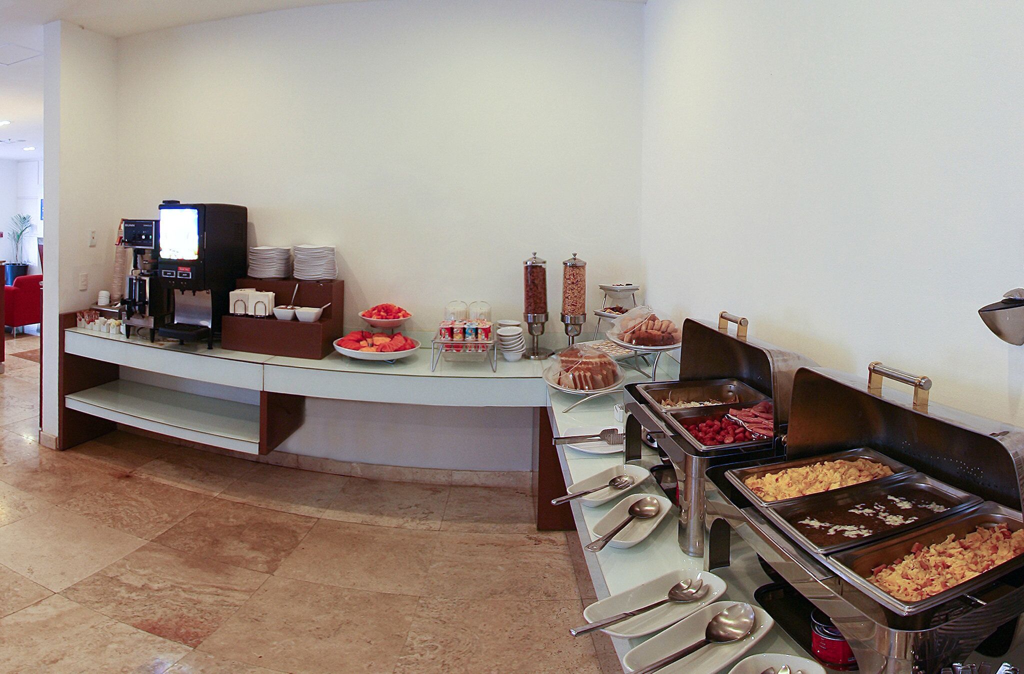 A buffet setup with various food items and serving utensils.