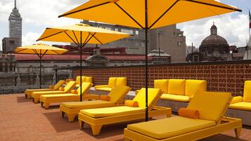 Alberca al aire libre, sombrillas en la alberca y camastros