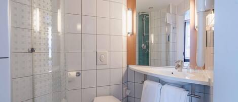 Un baño moderno con ducha, inodoro y lavamanos.