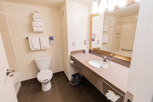 A hotel bathroom with a toilet, sink, and towel rack.