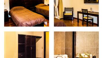 A hotel room with a bed, a desk, a chair, and a bathroom with a sink and mirror.