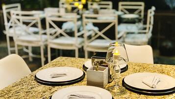 A dining table set with plates, napkins, and a candle centerpiece.