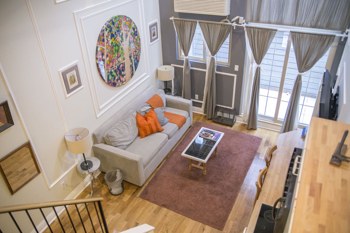 A living room with a sofa, coffee table, and a large window with curtains.