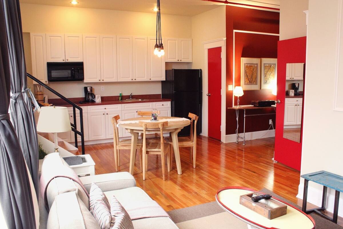 A modern apartment with a kitchen, dining area, and living room.