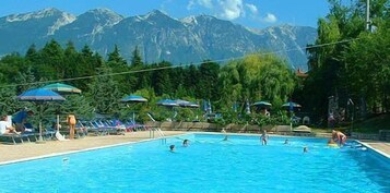 Una piscina al aire libre, sillones reclinables de piscina
