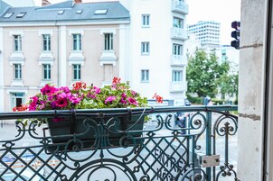 Un balcon agrémenté d’un jardinier et d’une balustrade en fer forgé.