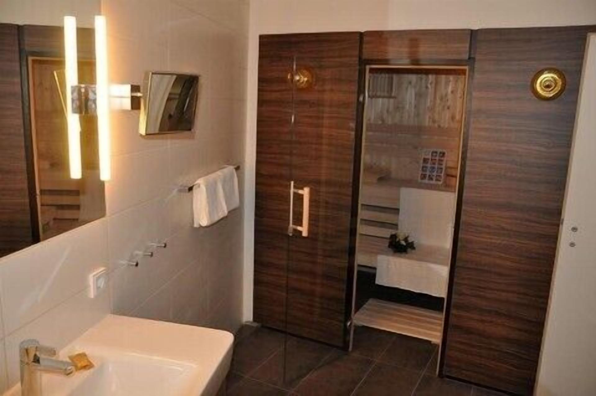 Un baño moderno con un espejo grande, una bañera y zona de ducha.