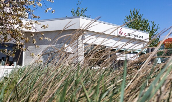 A restaurant with a white exterior and a sign that reads "Bene Restaurant."