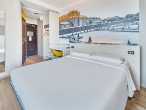 Una habitación de hotel moderna con una cama grande, un escritorio y una silla.