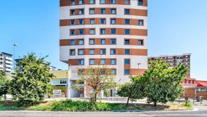 Un edificio de hotel de varios pisos con un llamativo letrero de B&B Hotels.
