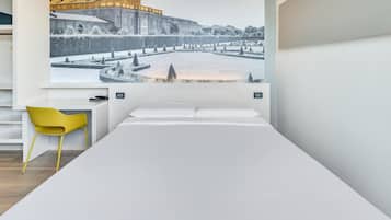 Una habitación de hotel moderna con una cama grande, un sillón amarillo y un mural en la pared con un castillo.