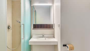 A bathroom with a shower, a sink, and a mirror.