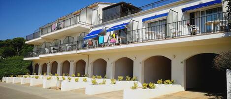 Un hotel de varios pisos con asientos al aire libre y una terraza cubierta.