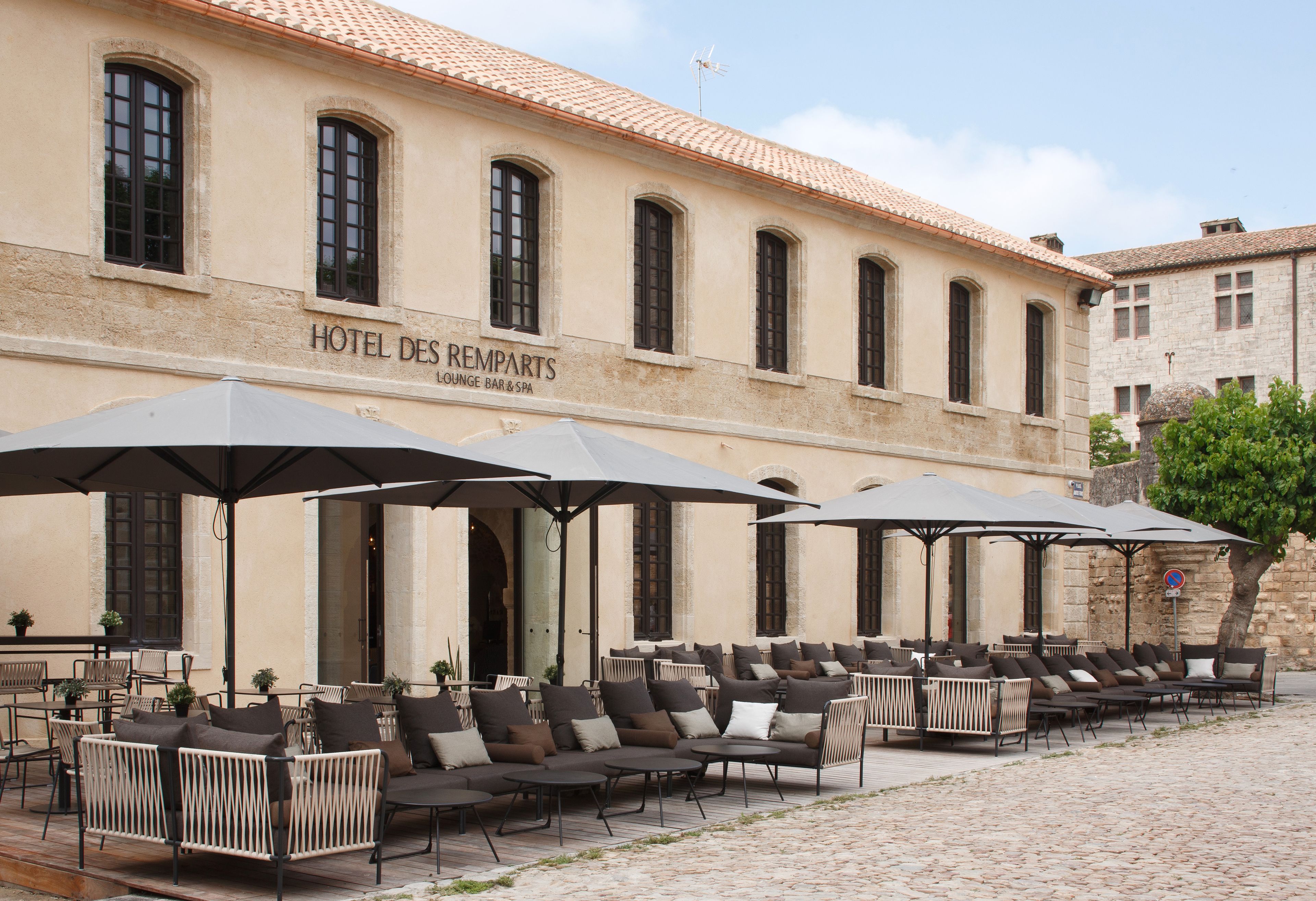 A hotel with outdoor seating, a terrace, and a sign indicating it is a lounge, bar, and spa.