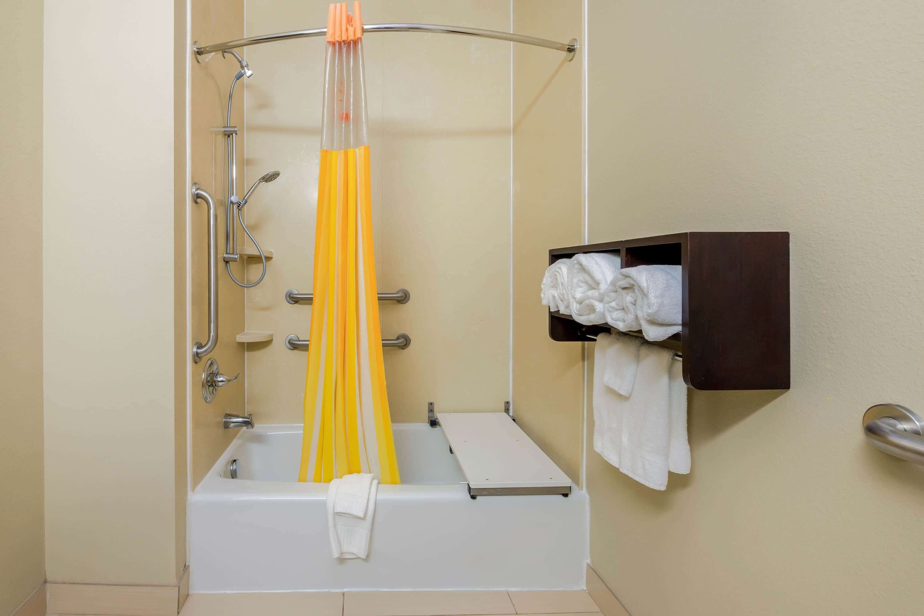 A bathroom with a bathtub, a shower, and a towel rack.