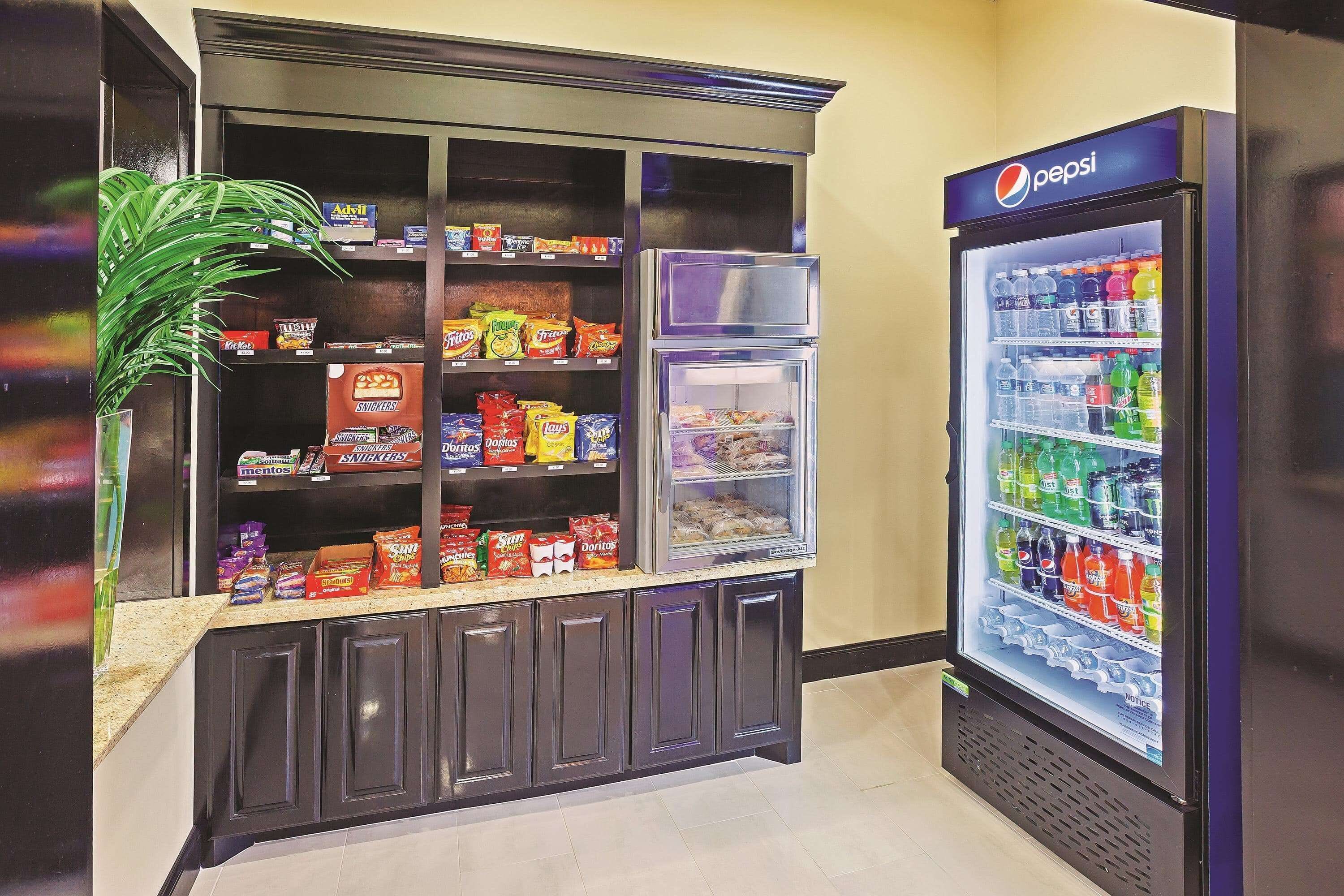 Un distributeur automatique rempli d’en-cas et un réfrigérateur contenant des boissons Pepsi.