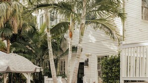 A pool area with lounge chairs, a small table, and a thatched umbrella.