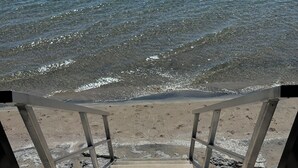 A wooden staircase leading to a beach with a metal railing. - Timber House Resort (Brighton)