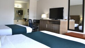 A hotel room with two beds, a desk with a computer, a TV, a mirror, and a bathroom visible through an open door. - Studio 6 Suites Chattanooga, TN - Lookout Mtn. (Chattanooga)