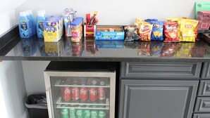 A kitchen counter with various food items and a refrigerator stocked with beverages. - Studio 6 Suites Chattanooga, TN - Lookout Mtn. (Chattanooga)
