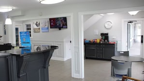 A modern kitchen with a coffee machine, a TV mounted on the wall, and a sign about a 6-month membership. - Studio 6 Suites Chattanooga, TN - Lookout Mtn. (Chattanooga)
