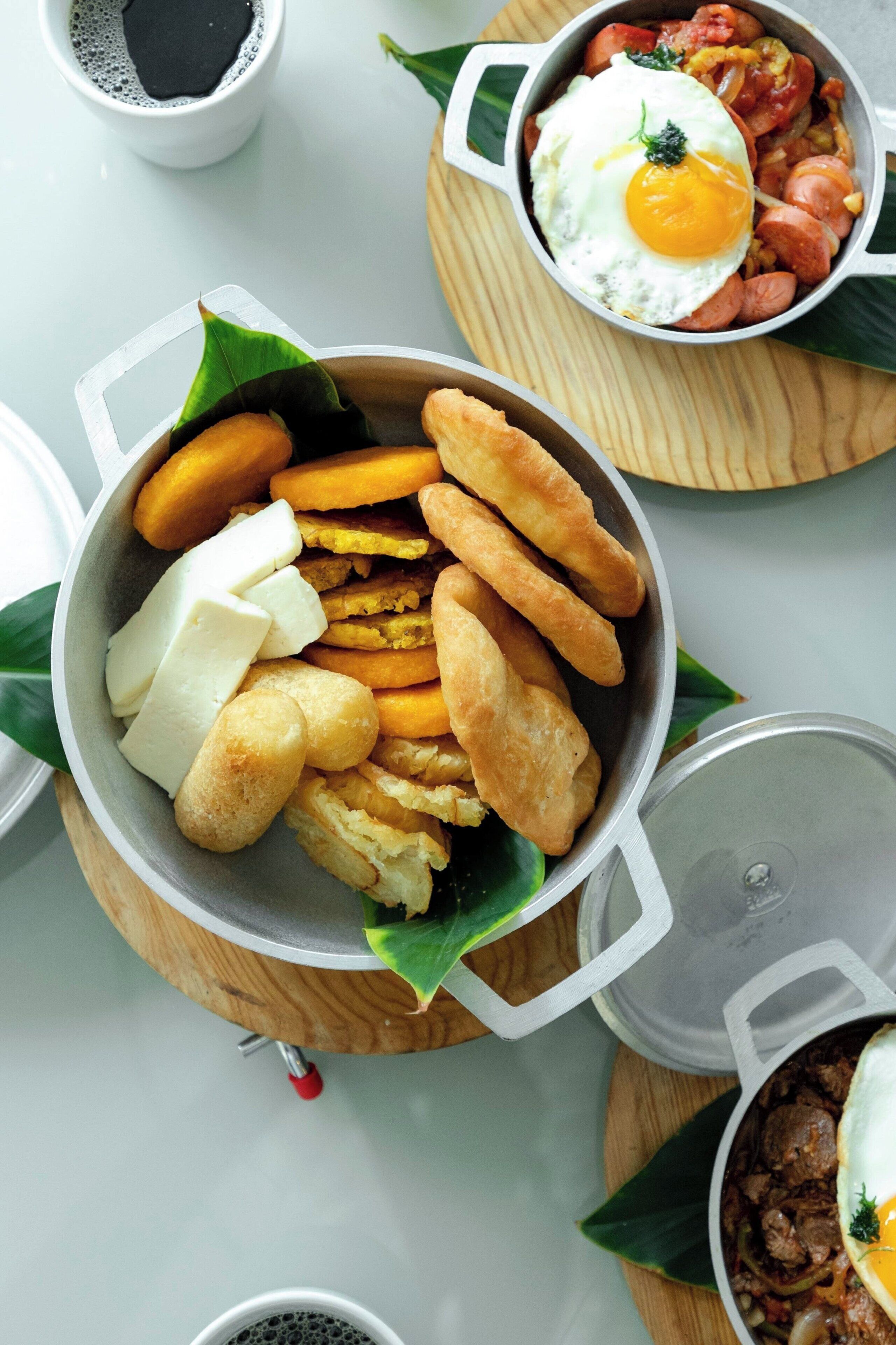 A variety of food items including fried dough, cheese, and a dish with eggs and vegetables.
