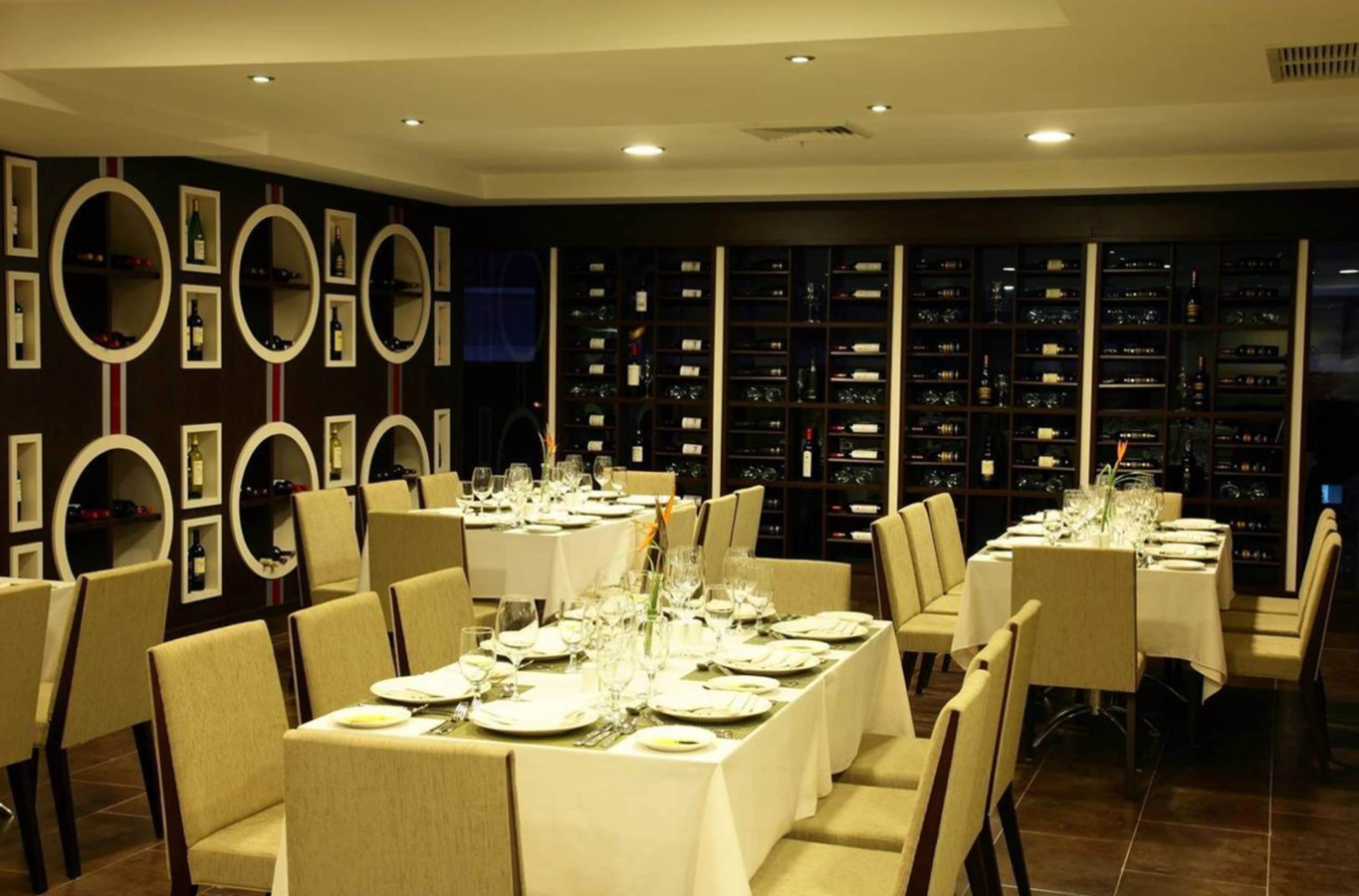 A dining area with long tables set for a meal, surrounded by chairs.