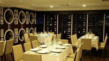 A dining area with long tables set for a meal, surrounded by chairs.