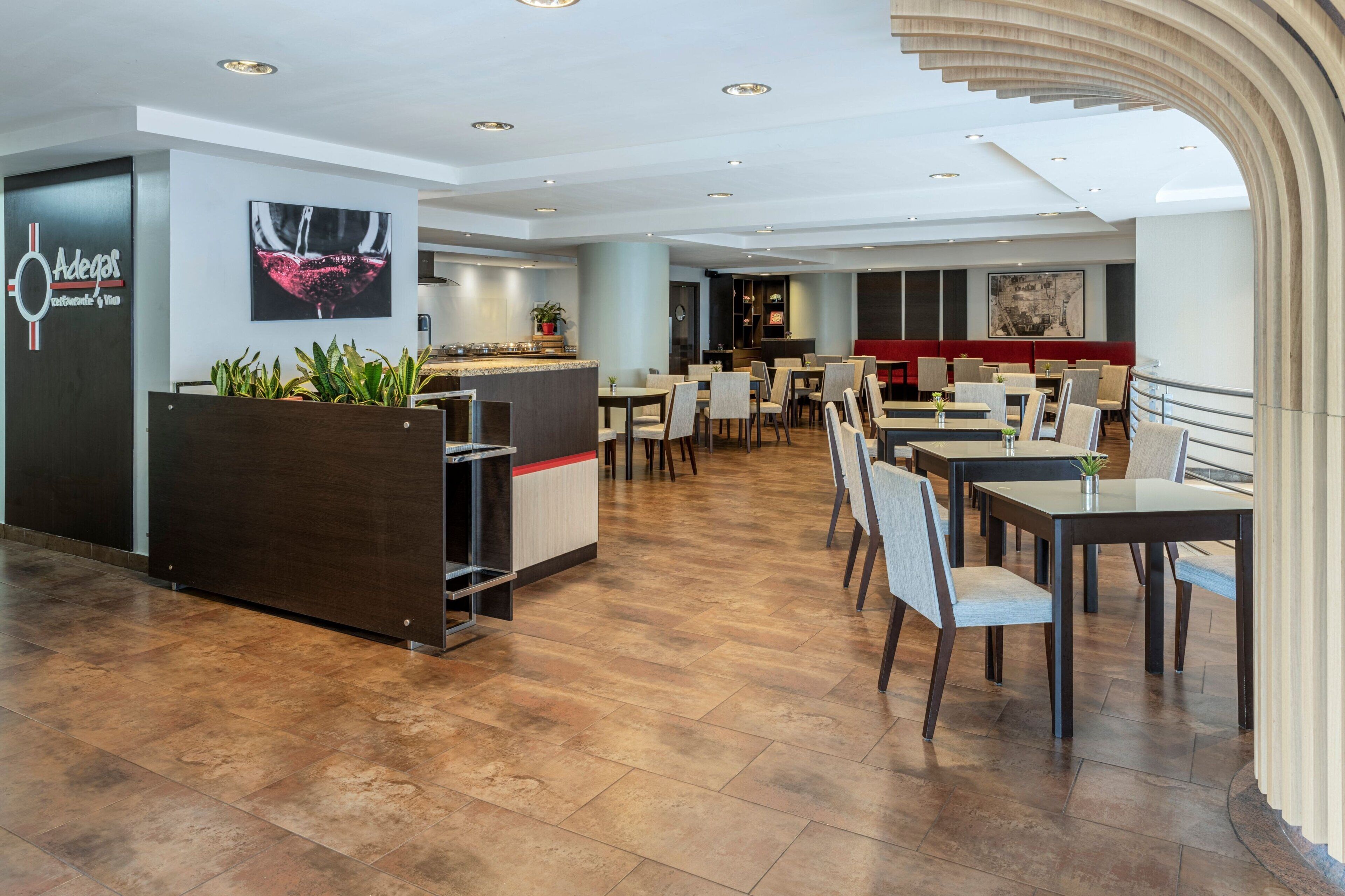 A modern restaurant with a bar area, seating arrangements, and a large window.
