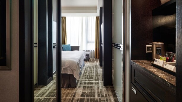 A hotel room with a bed, a desk, a television, and a minibar. - The Tango Taipei Nanshi (Taipei)