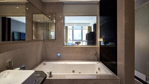 A modern bathroom with a large bathtub, a sink, and a mirror. - The Tango Taipei Nanshi (Taipei)
