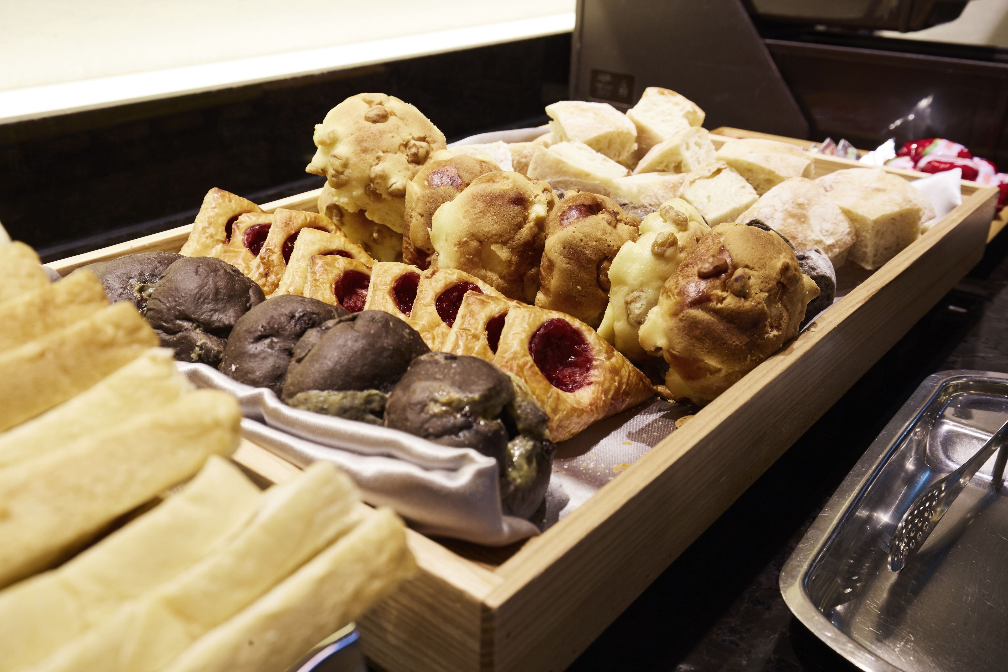 A wooden tray filled with various pastries and desserts.