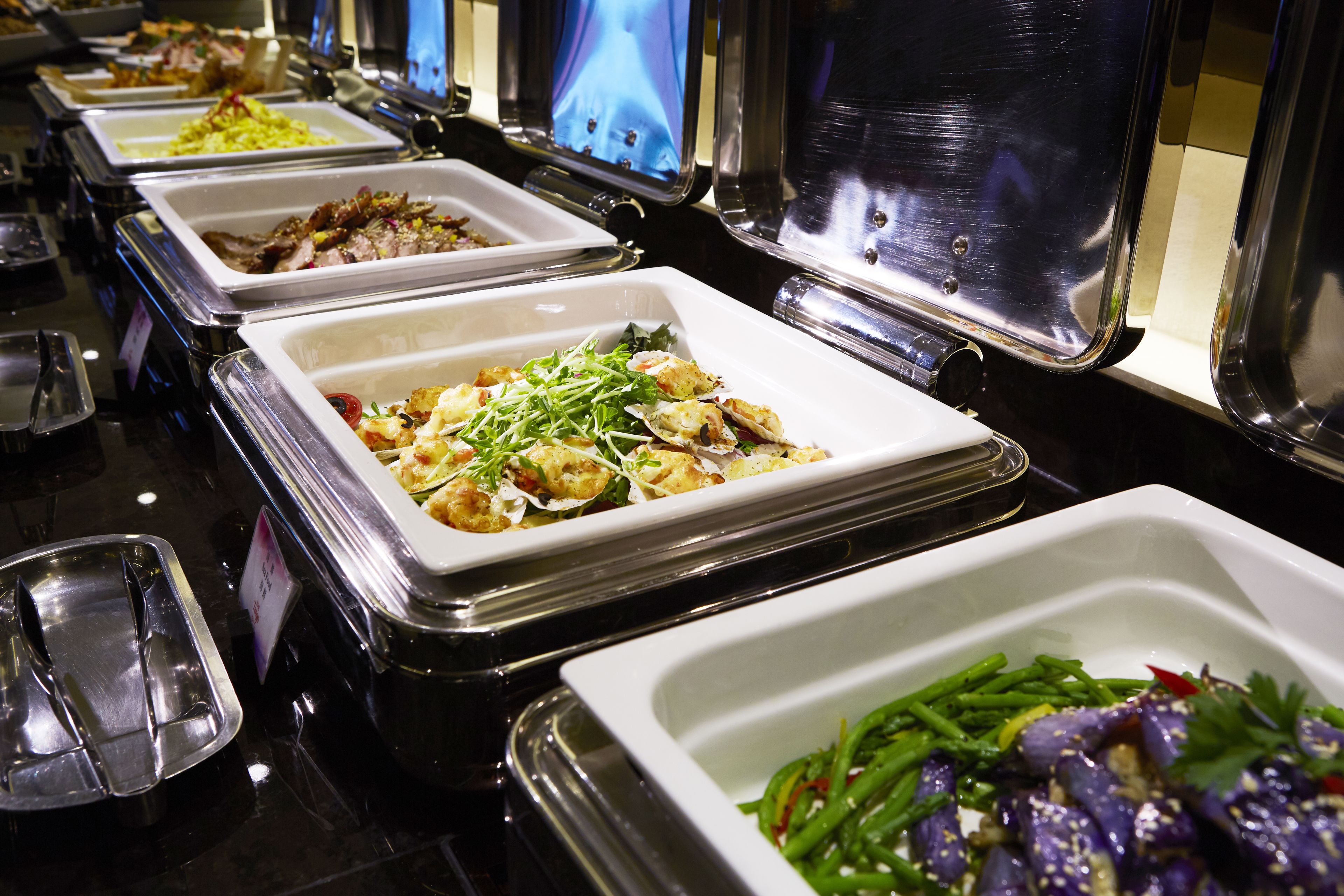 A buffet with various dishes including seafood, salads, and vegetables.
